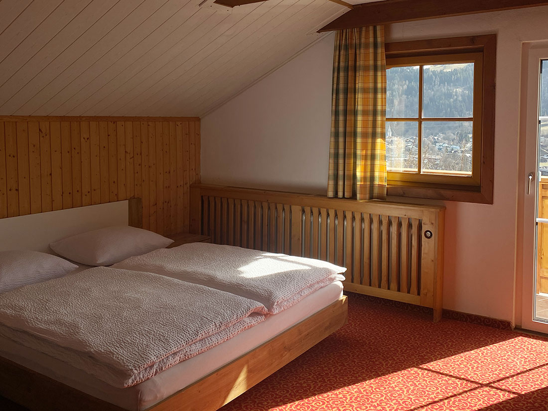 gemütliches Schlafzimmer mit Balkon und Aussicht auf Schladming und die Ennstaler Alpen